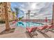 Relaxing outdoor pool area featuring lounge chairs, palm trees, and a clear swimming pool for residents at 2405 W Serene Ave # 703, Las Vegas, NV 89123