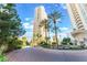 Circular driveway leading to a modern high-rise building with manicured landscaping at 2877 Paradise Rd # 1806, Las Vegas, NV 89109