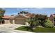 Attractive single-story home with a two-car garage, palm trees and desert landscaping, creating curb appeal at 2986 Matese Dr, Henderson, NV 89052