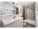 Bathroom with a large mirror, white vanity, shower over tub with tiled surround and gray wood-look flooring at 3120 S Eastern Ave # 5, Las Vegas, NV 89169