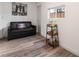 Living room with a black futon, dark wood shelf, wood-look floors, white walls, and a window at 3120 S Eastern Ave # 5, Las Vegas, NV 89169