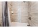 Close up on a shower over tub, featuring gray horizontal tile, a shower caddy, and handheld shower head at 3120 S Eastern Ave # 5, Las Vegas, NV 89169