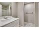 Modern bathroom featuring white cabinets, vanity, and a shower with glass doors at 3166 Via Da Vinci, Henderson, NV 89044