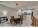 An eat-in kitchen features a wood dining table with modern chandelier at 3166 Via Da Vinci, Henderson, NV 89044