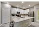 A kitchen island features white countertops and stainless steel appliances at 3166 Via Da Vinci, Henderson, NV 89044