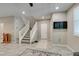 Stylish living room with stairs, tiled flooring, wall mounted TV, and neutral decor at 3166 Via Da Vinci, Henderson, NV 89044