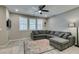 Comfortable living room with a gray sectional sofa, plantation shutters, and modern decor at 3166 Via Da Vinci, Henderson, NV 89044