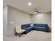 Comfortable living room featuring a blue sectional sofa, accent chair, and a ceiling fan at 3166 Via Da Vinci, Henderson, NV 89044