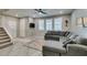 Bright and airy living room with staircase, tiled floors, and comfortable gray sectional sofa at 3166 Via Da Vinci, Henderson, NV 89044