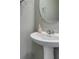 Elegant powder room with pedestal sink, round mirror, and modern fixtures at 3166 Via Da Vinci, Henderson, NV 89044