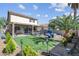 Landscaped backyard featuring an outdoor kitchen, grass area, and lounge seating at 3186 Lapis Beach Dr, Las Vegas, NV 89117