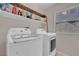 Bright laundry room featuring a washer and dryer, a window and storage shelves at 3186 Lapis Beach Dr, Las Vegas, NV 89117