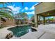 Backyard pool featuring a rock waterfall feature, tropical landscaping, a covered patio, and ample deck space at 3217 Palladio Ave, North Las Vegas, NV 89031