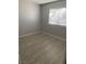 Neutral bedroom with light gray walls, wood-look flooring, and natural light streaming in from the window at 3450 Erva St # 167, Las Vegas, NV 89117
