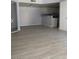 Open-concept living room featuring light gray walls and light wood-look flooring leading into the adjacent kitchen at 3450 Erva St # 167, Las Vegas, NV 89117