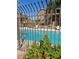 Community pool with clear blue water, surrounded by a fence and greenery at 3450 Erva St # 167, Las Vegas, NV 89117