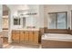 Bathroom featuring a large bathtub, vanity with sink, and neutral colored tiles at 3525 Tuscany Village Dr, Las Vegas, NV 89129