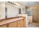 This bathroom features a granite countertop, wooden cabinets, and a glass block shower at 3525 Tuscany Village Dr, Las Vegas, NV 89129