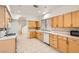 A well-lit kitchen featuring light wood cabinets, tiled countertops, and tiled floors at 3525 Tuscany Village Dr, Las Vegas, NV 89129