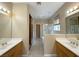 Bright bathroom featuring double sinks, a glass-enclosed shower, and ample counter space at 3567 Cottage Stream Ct, Laughlin, NV 89029