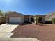 Attractive single-story home featuring a desert front yard and a two-car garage at 3567 Cottage Stream Ct, Laughlin, NV 89029