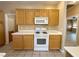 Kitchen showcasing white appliances, wood cabinets, and tile flooring at 3567 Cottage Stream Ct, Laughlin, NV 89029