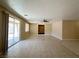 Open living room with neutral walls, tile floors, and large sliding glass door to the backyard at 3567 Cottage Stream Ct, Laughlin, NV 89029