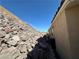 Side yard showing a rock wall and the home's exterior at 3567 Cottage Stream Ct, Laughlin, NV 89029