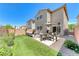 Well-manicured backyard with artificial grass, patio, seating, and dining areas at 358 Badinerie St, Henderson, NV 89011