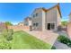 Paver-stone patio with faux grass and seating area, bordered by manicured landscaping, offers a cozy backyard retreat at 358 Badinerie St, Henderson, NV 89011