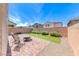 A well-kept backyard featuring faux grass, stone pavers, mature landscaping, and a seating area at 358 Badinerie St, Henderson, NV 89011