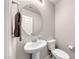 Modern half-bathroom with pedestal sink, round mirror, and neutral walls at 358 Badinerie St, Henderson, NV 89011