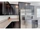Stylish kitchen featuring dark cabinetry, stainless steel refrigerator, and granite countertops at 358 Badinerie St, Henderson, NV 89011