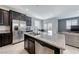 Open kitchen with island, stainless steel appliances, granite counters, and access to backyard at 358 Badinerie St, Henderson, NV 89011