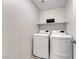 Modern laundry room with white washer and dryer units and a shelf at 358 Badinerie St, Henderson, NV 89011