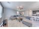 Bright living room with large sectional sofa, ceiling fan, tile floors, and nearby kitchen at 358 Badinerie St, Henderson, NV 89011