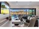 Bright living room showcasing a fireplace, comfortable seating, and stunning lake views through sliding glass doors at 36 Lakefront Dr, Henderson, NV 89011