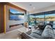 Relaxing living room featuring fireplace, TV, and comfortable seating, with scenic views from the large sliding glass doors at 36 Lakefront Dr, Henderson, NV 89011