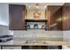 Modern kitchen featuring granite countertops, stainless sink, dark cabinets and decor on an open shelf at 3924 Blackford Pl, Las Vegas, NV 89102