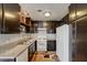 Well-lit kitchen equipped with dark cabinets, granite countertops, white appliances, and patterned flooring at 3924 Blackford Pl, Las Vegas, NV 89102
