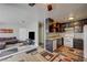 Cozy kitchen features dark cabinets, granite countertops, and white appliances adjoining a comfortable living area at 3924 Blackford Pl, Las Vegas, NV 89102