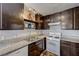 Classic kitchen with granite countertops, stainless sink, dark wood cabinets, and a white range stove at 3924 Blackford Pl, Las Vegas, NV 89102