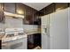 Intimate view of the kitchen area, highlighting dark wood cabinetry, granite countertops, and a white refrigerator at 3924 Blackford Pl, Las Vegas, NV 89102