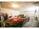 Organized two-car garage featuring a red sports car, ample storage, and an automatic door opener at 4465 Shimmering Skies St # 2180, North Las Vegas, NV 89031