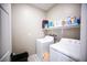 Well-lit laundry room featuring a washer, dryer, storage shelf, and tiled floors at 4465 Shimmering Skies St # 2180, North Las Vegas, NV 89031