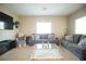 Comfortable living room with gray sofas, area rug, and a large TV at 4465 Shimmering Skies St # 2180, North Las Vegas, NV 89031