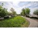 Scenic community park featuring a paved walking path, mature trees, and lush green grass at 4465 Shimmering Skies St # 2180, North Las Vegas, NV 89031