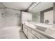 A spacious bathroom includes double sinks, white cabinets, and a shower over the tub at 4504 Dunlap Crossing St, Las Vegas, NV 89129