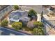 An aerial view of the home's backyard, including a long carport, mature trees, a tile roof, and solar panels at 5193 N Miller Ln, Las Vegas, NV 89149