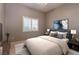 Comfortable bedroom with a ceiling fan, plush bedding, and modern accents at 5193 N Miller Ln, Las Vegas, NV 89149